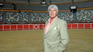 Retrato editorial de Luis Álvarez en una plaza de toros, rodeado por elementos discretos que recuerdan su trayectoria como apoderado y empresario.