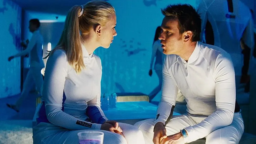 una composición editorial futurista con una instalación biomédica, un organoide iluminado dentro de una cápsula de laboratorio y una silueta humana reflejada en el cristal. Evitar representar clones humanos como una realidad existente.